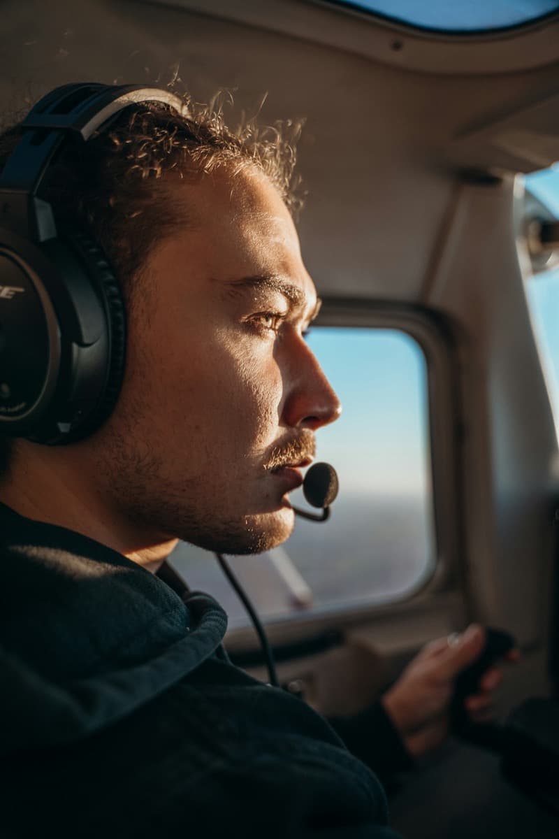 Piloto con auriculares comunicando por radio desde la cabina de una avioneta