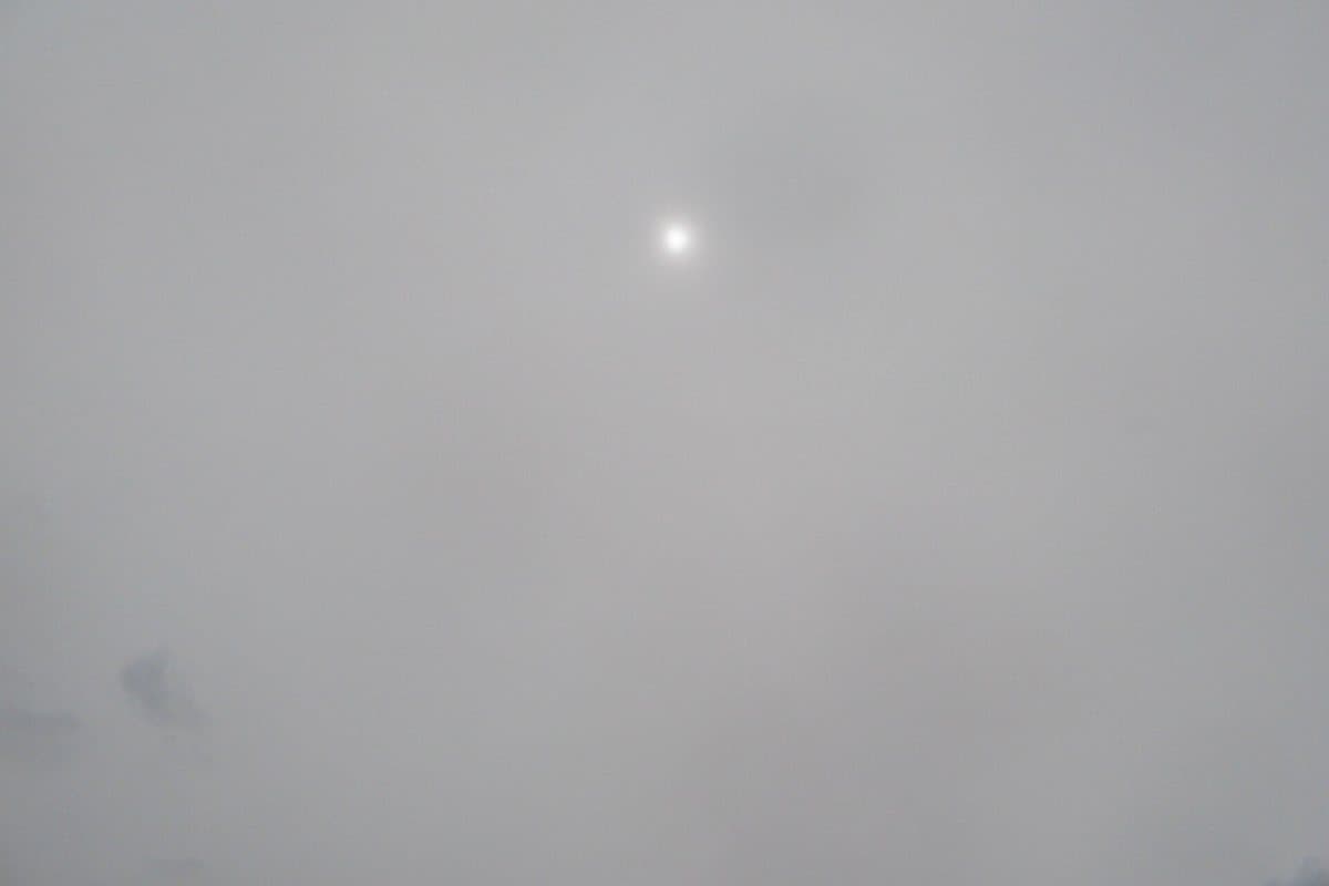 Altostratos: capa gris uniforme; el sol se ve como un punto borroso, sin halo.