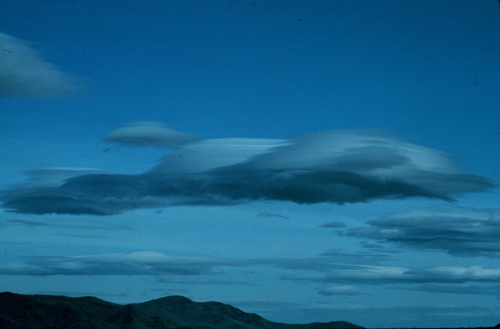 Altocúmulos lenticulares: nubes lisas en forma de lente sobre una sierra.